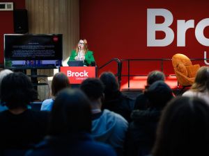 A woman speaks to an audience while standing at a podium.
