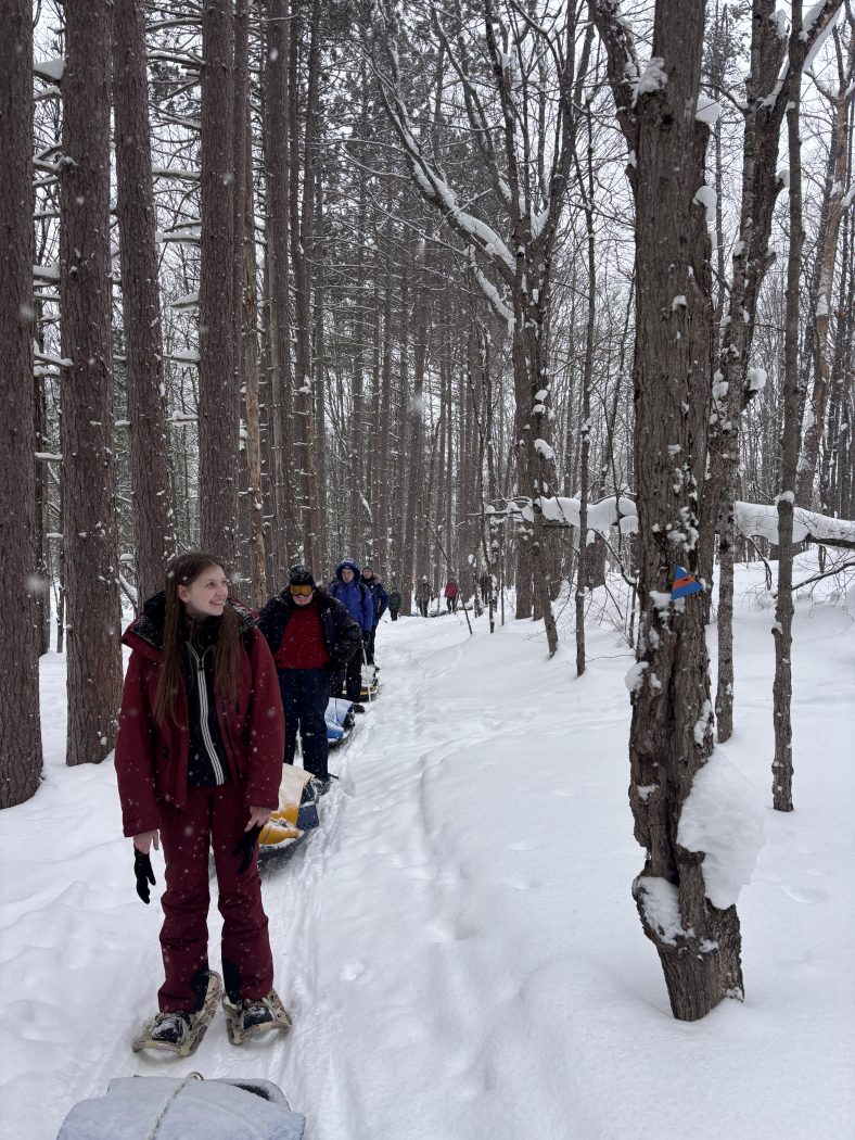 A group of university students hike in the snow.