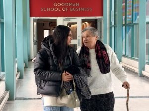 A young woman and an older woman walk down a hallway together.
