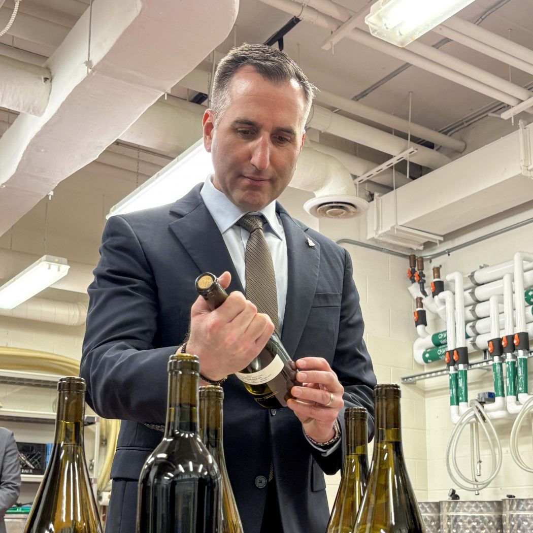 A man examines a wine bottle