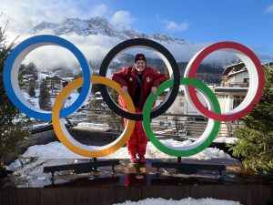 A woman peeks through the centre ring of an Olympic rings display, which featured five rings of different colours.