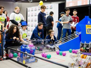 Teams of high school students compete at a robotics competition.