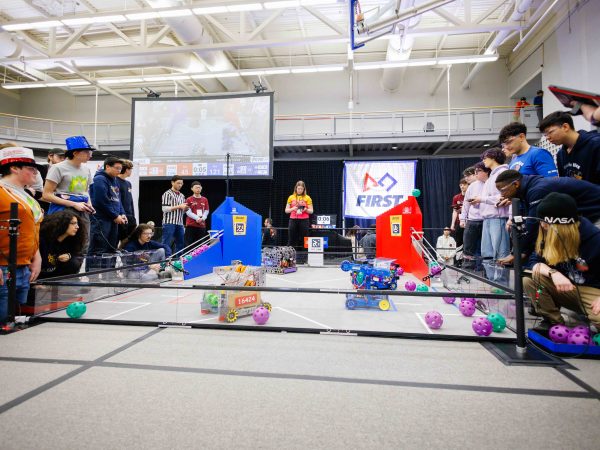 Teams of high school students compete at a robotics competition.