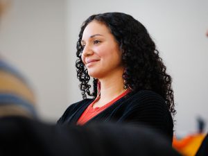 Close-up of an attendee listening attentively, wearing red beaded earrings and a black sweater.
