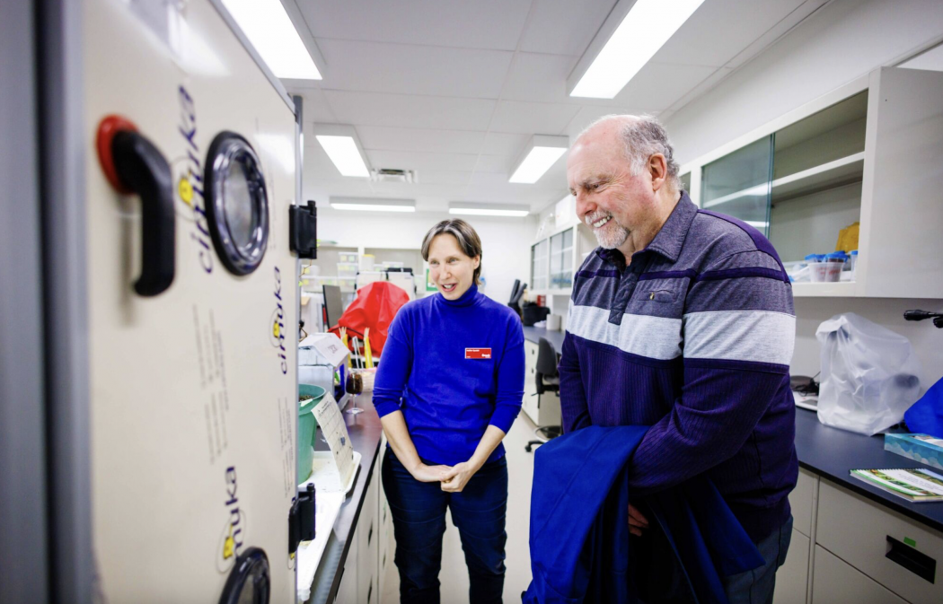 Two people look at a piece of equipment
