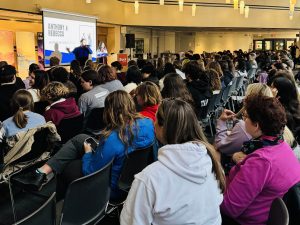 A large audience looks to the front of a room during an event.