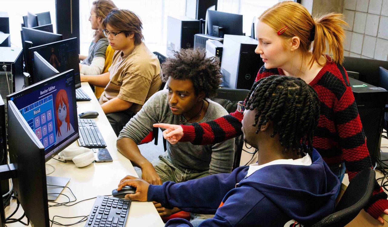 A group of university students work in a computer lab together.