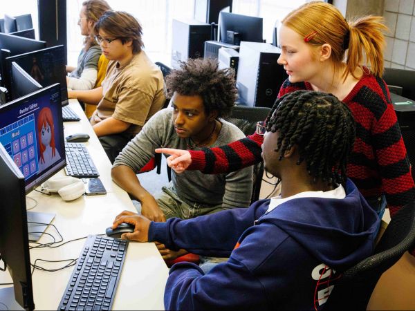 A group of university students work in a computer lab together.