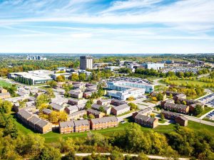 A wide view of Brock University’s main campus, featuring modern campus buildings beneath a bright blue sky.