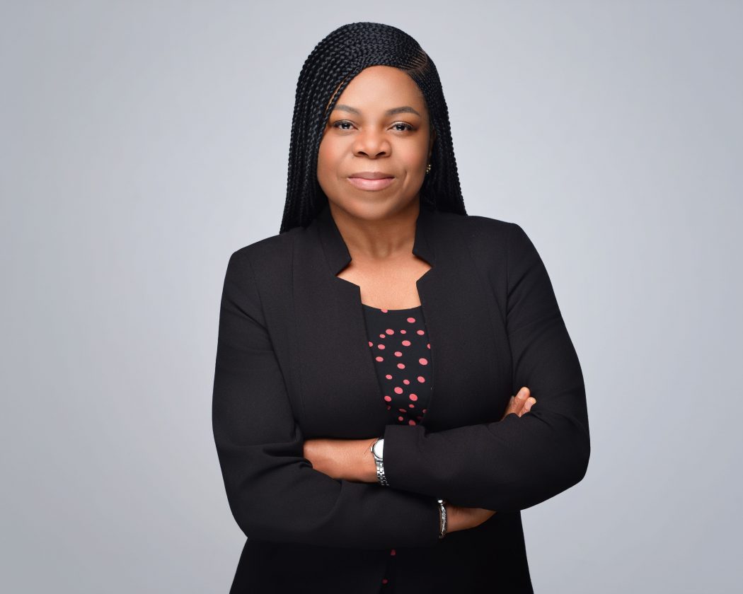 A woman stands with her arms crossed.