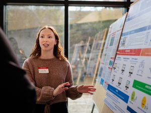A woman speaks about her research poster.