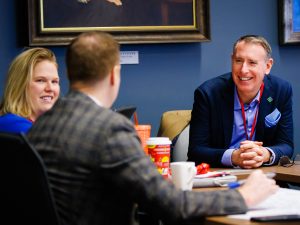 Three people chat at a business event.