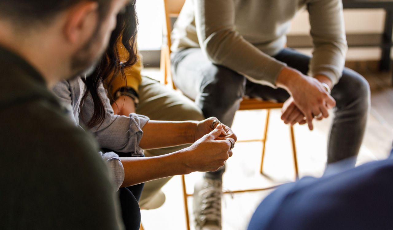 Close-up of a circle of people having an intense conversation while sitting in a circle.