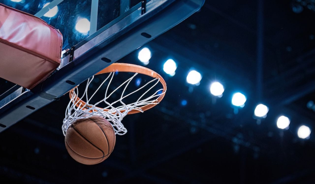 Basketball goes through a net.
