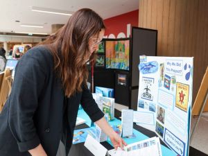 A woman looks at information on a table at a fair in a university.