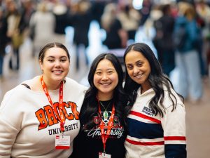 Three women in Brock shirts pose for a photo at a Brock University event.