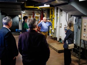 A group of people tour a utilities area in a university.