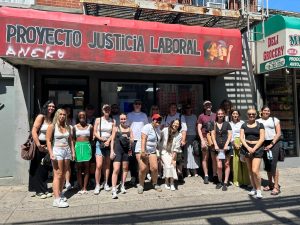 A group of university students outside a storefront.