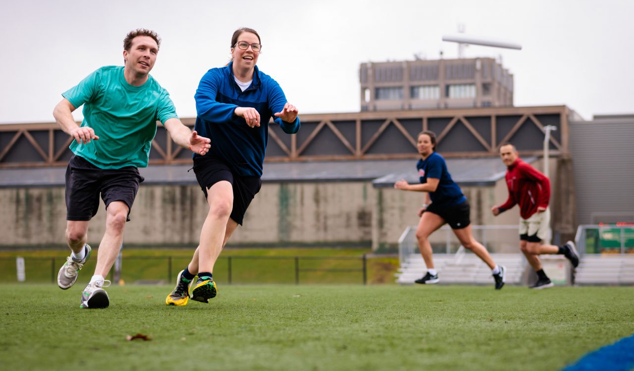Four people play ultimate Frisbee on an outdoor field at Brock University.