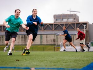 Four people play ultimate Frisbee on an outdoor field at Brock University.