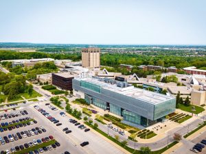 A wide view of Brock University’s main campus, featuring modern campus buildings beneath a bright blue sky.