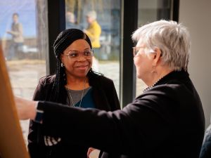 Two people look at a poster while talking.