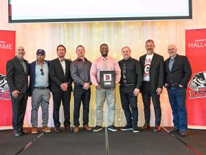 A group of men pose with an award on stage.