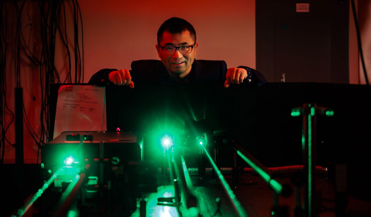A man uses a laser in a research lab.