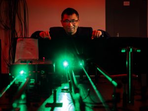 A man uses a laser in a research lab.