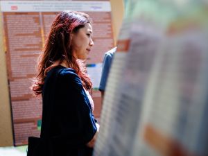 An attendee looks at a poster presentation during a Health, Art and Justice Lab event.
