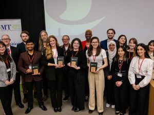 A group of people stand together holding awards.