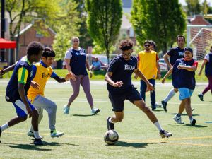 People play soccer on a field at a university.
