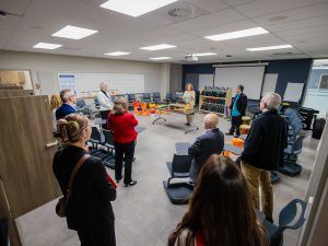 People watch an educator demonstrate musical instruments during a classroom tour.