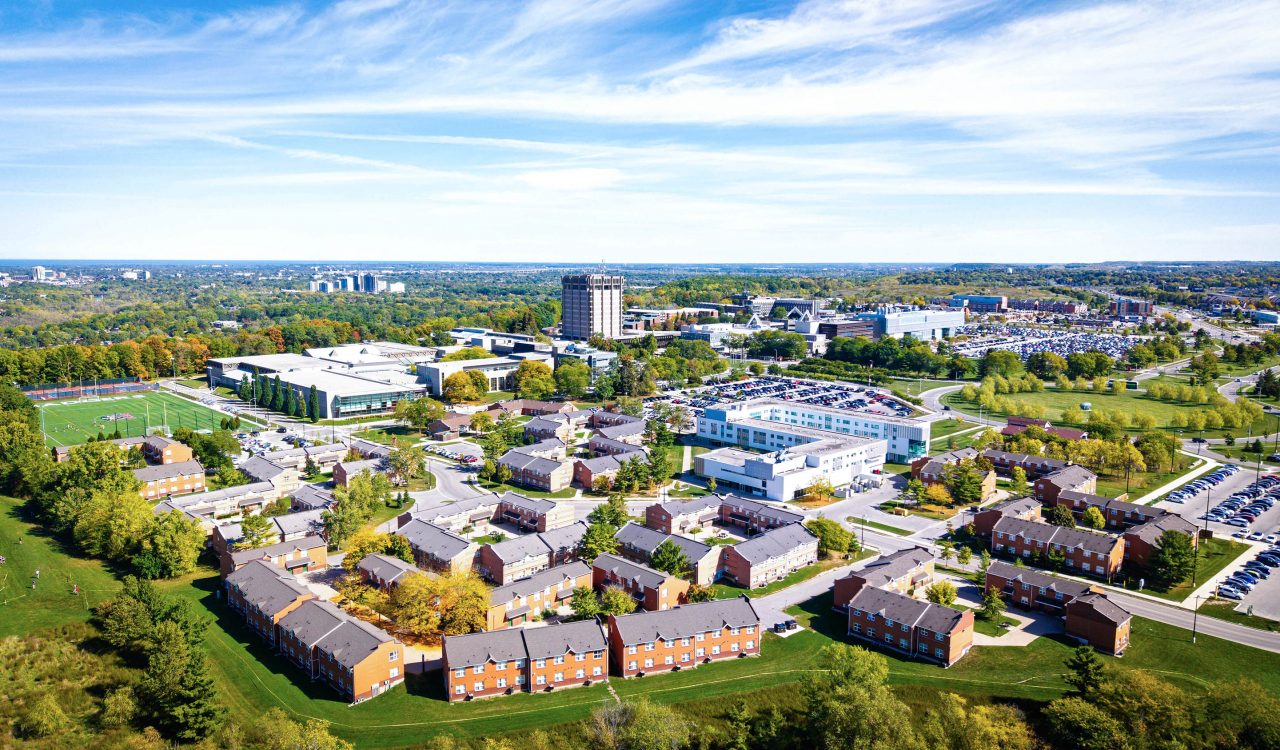 An aerial view of a university campus with a wide variety of buildings surrounded by green space.
