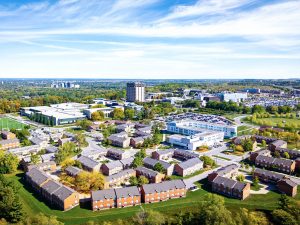 An aerial view of a university campus with a wide variety of buildings surrounded by green space.