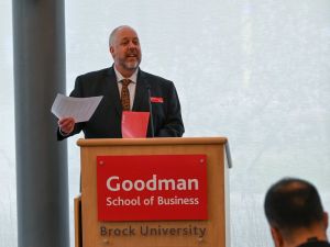 A man speaks from a podium to an audience.