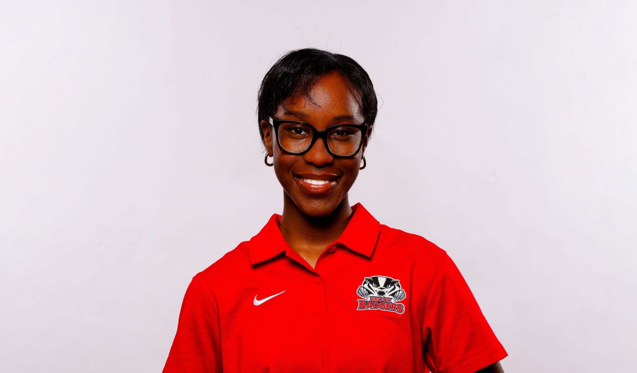 A university students smiles against a white backdrop.
