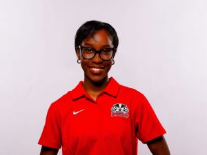 A university students smiles against a white backdrop.