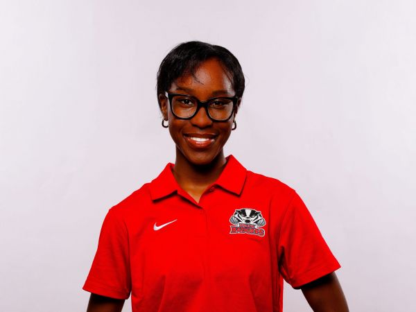 A university students smiles against a white backdrop.
