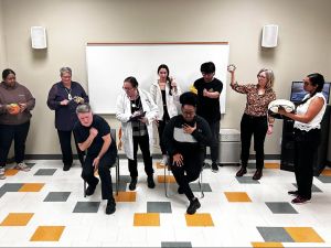 A group of people act out a health-care scenario in a play.
