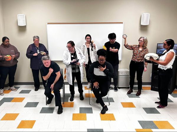 A group of people act out a health-care scenario in a play.