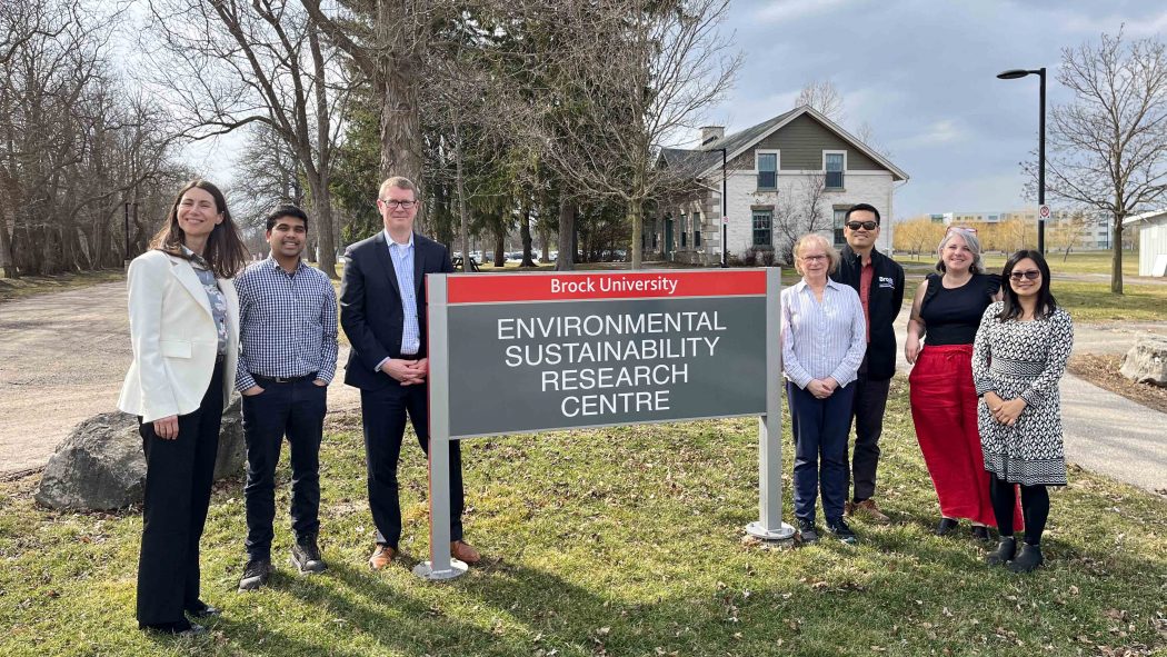A group of people standing by the Environmental Sustainability Research Centre sign.