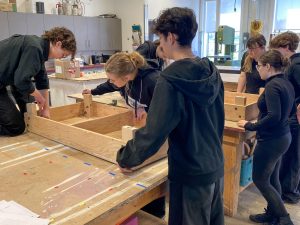 Students work on a stage set in a scenic construction studio.