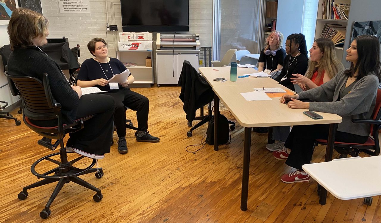 A group of students rehearse a play in a university classroom.