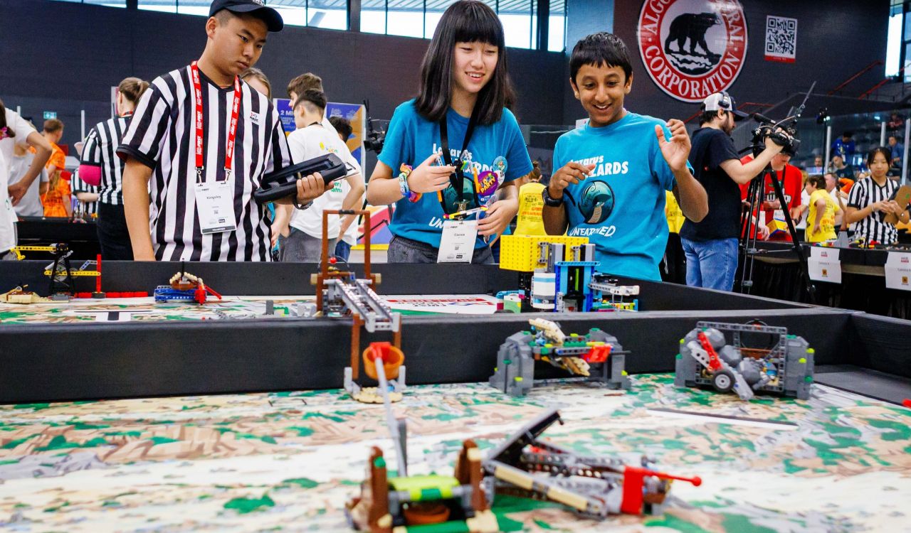 A boy and a girl on a team competing with robots built from LEGO Education robotics technology.