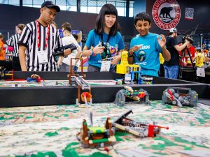 A boy and a girl on a team competing with robots built from LEGO Education robotics technology.