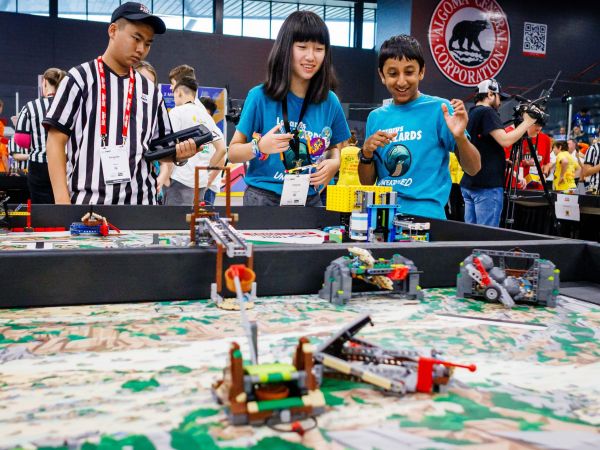 A boy and a girl on a team competing with robots built from LEGO Education robotics technology.