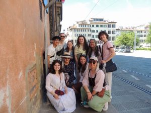 A small group of people stand on the streets of Florence, Italy on a sunny day.