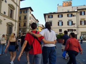 A group of people walk together looking at the Piazza del Duomo in Florence, Italy.