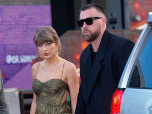 Taylor Swift and Travis Kelce are seen walking hand in hand outside.